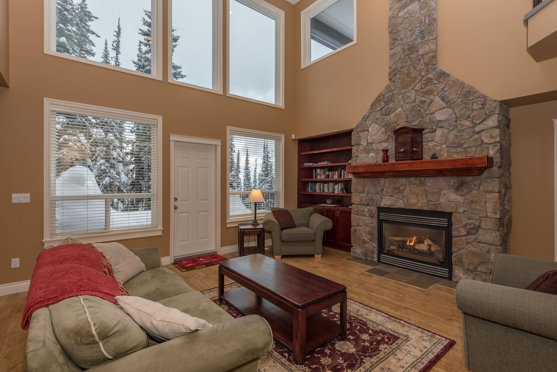 Full Living Room with large gas fireplace, large bright open windows with deck outside and BBQ. Home features private hot tub, private laundry, garage for parking or storage, and it's pet-friendly! Ski in and out right from your door to the skiway and access the village in minutes.